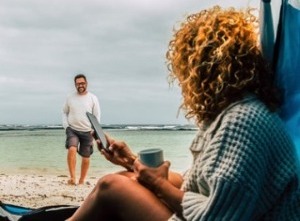 Woman checking her account on a phone while on beach vacation