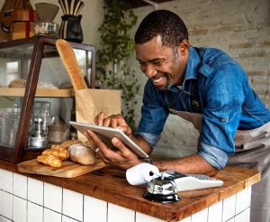 Bakery owner checking account on his tablet