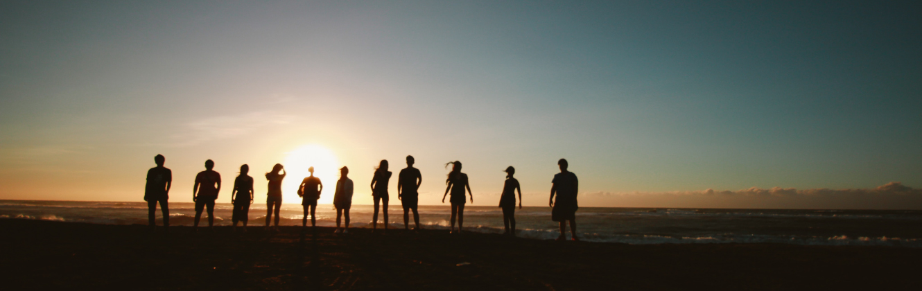 Silhouettes of people on beach during a sunset