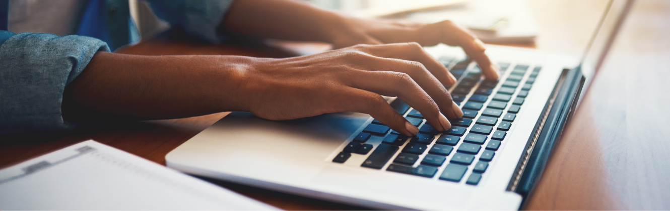 A woman typing on a laptop computer