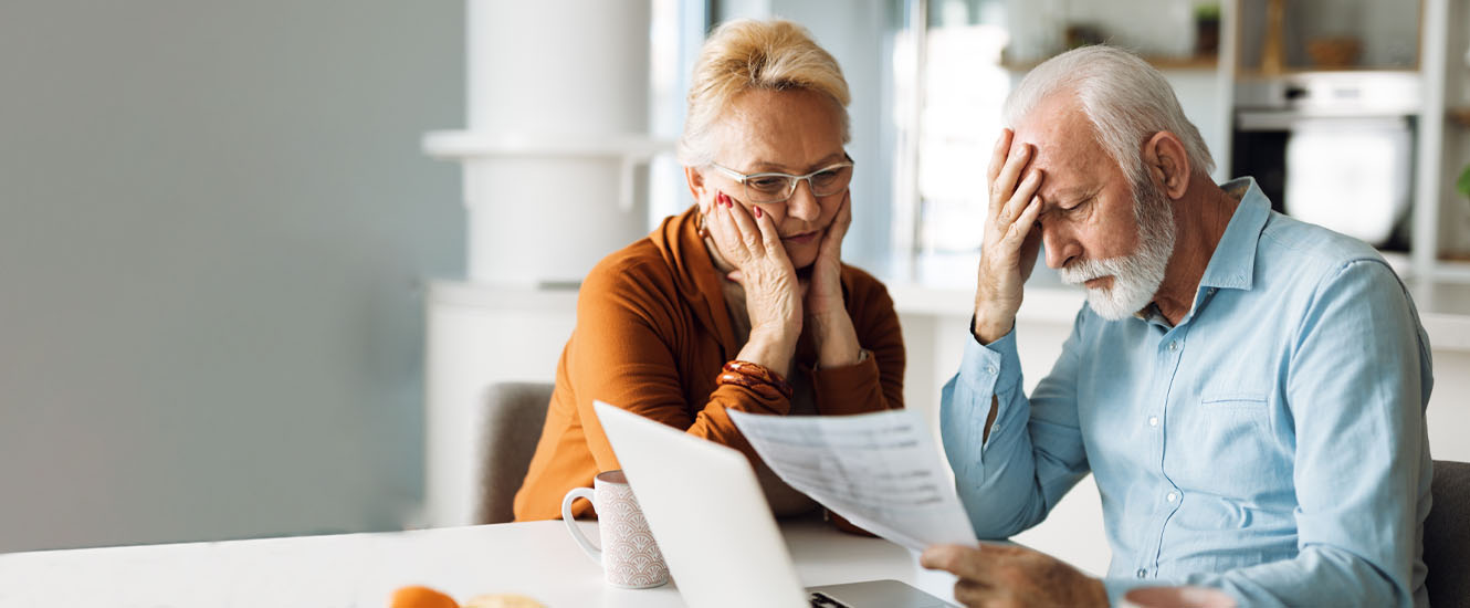 Distressed seniors looking at financial documents